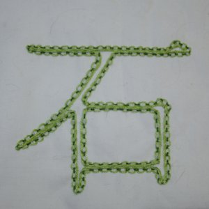 Beispiel f&uuml;r chinesisch durchzogenen Vorstich: Das Kanji f&uuml;r Rechts in dunkelgr&uuml;nem Vorstich, chinesisch durchzogen in hellgr&uuml;n. Vorlage in Pinselschrift.