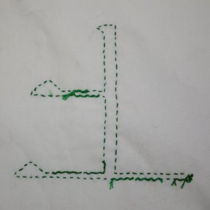 Beispiel f&uuml;r umschlungenen Vorstich, R&uuml;ckseite: Das Kanji f&uuml;r Wind in hellgr&uuml;nem Vorstich, umschlungen in Dunkelgr&uuml;n. Vorlage in Pinselschrift.