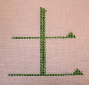 Kreuzstich-Beispiel: Das Kanji f&uuml;r Erde in gr&uuml;nem Kreuzstich auf feinerem Leinengrund, Vorlage in Pinselschrift.