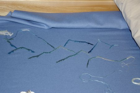 Blauer Radmantel, im Stickrahmen eingespannt, Hochgebirgsszene, 2-f&auml;diger Sticktwist in blau und gr&uuml;n.